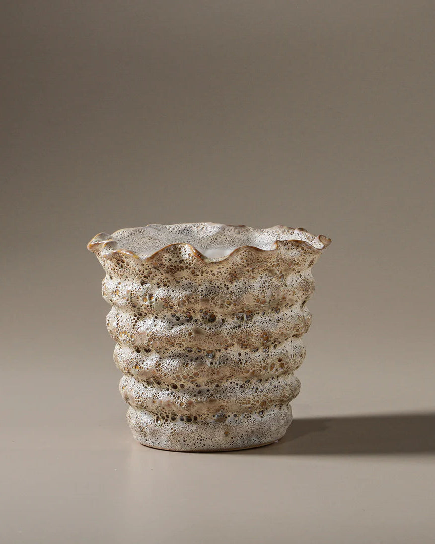 Textured ceramic vase on a beige background