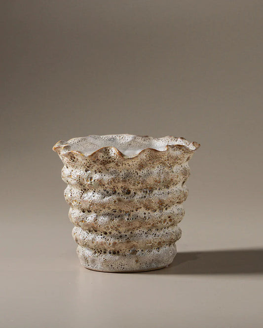 Textured ceramic vase on a beige background