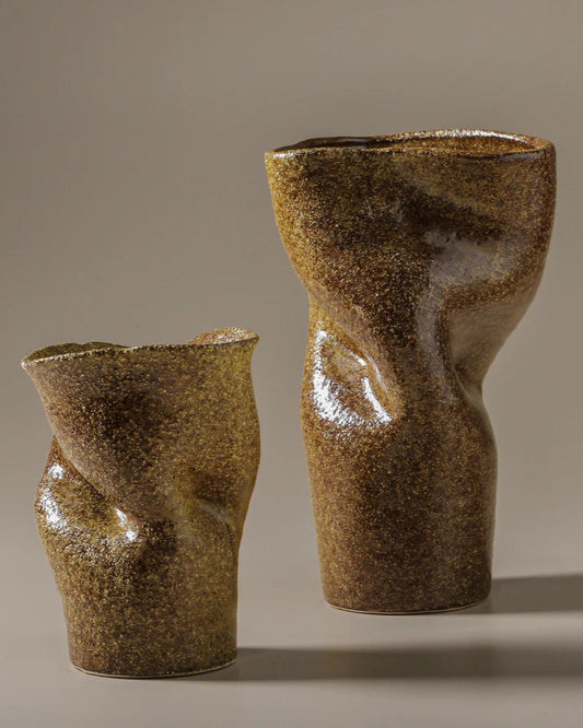 Two brown ceramic vases with textured surface on a beige background