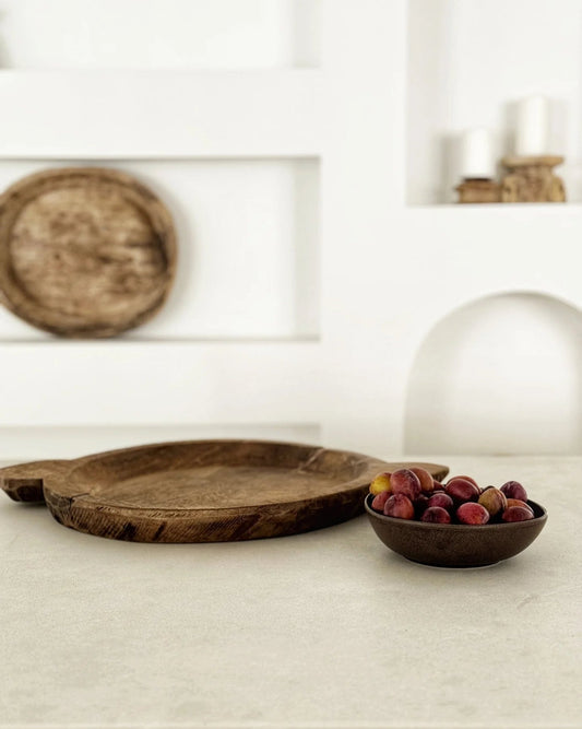 Wooden tray and bowl with fruits on a light surface