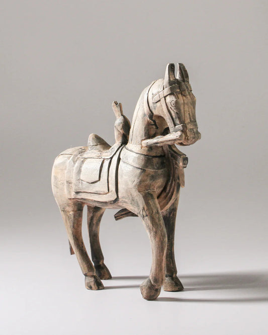Wooden horse figurine on a gray background